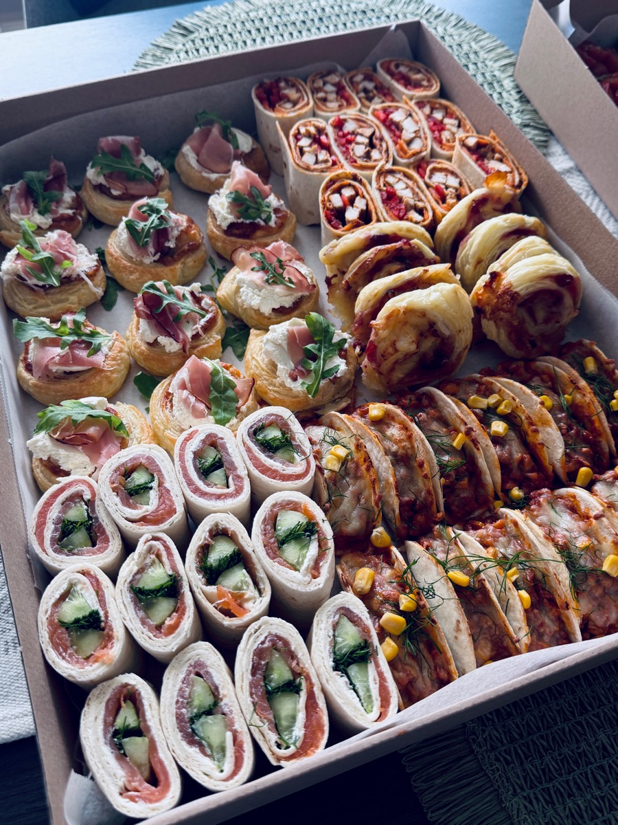 Duży box: rollsy francuskie z szynką i rukolą, roladki z łososiem i ogórkiem, wrapy z kurczakiem, zapiekane tacos z kukurydzą, croissanty